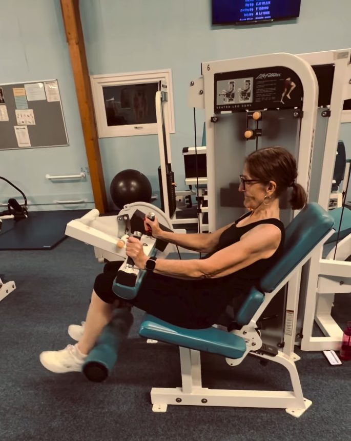 Ollie’s mum training on the leg curl machine at Empire Fitness